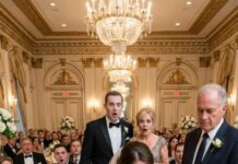 I was smiling through my daughter’s vows when her mother-in-law slid a velvet gift box onto the table. “For the bride,” she purred. My girl opened it—and a housekeeping uniform spilled into her shaking hands. My son-in-law laughed. “Perfect. Just what she’ll need at home.” My daughter’s eyes flooded, lips trembling. I stood up slowly. “Funny,” I said, placing my own box beside hers. “Because I brought a gift too… and it’s not for her.” When she lifted the lid, the room forgot how to breathe.