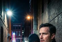 The wind cut through my coat like a blade, but nothing stung as much as the silence in my chest. Then a voice cracked the dark behind me: “Stop. You don’t get to disappear.” I froze. “You’re… dead,” I whispered. A laugh—too close, too familiar. “Am I?” My phone lit up with a single message: RUN. And that’s when I saw my own footprints… turning back.