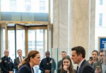 She walked into one of New York’s most prestigious banks wearing a faded coat and sneakers—quiet, polite, and asking for one simple thing: to withdraw $50,000 from her own account. But the teller looked her up and down and sneered like she didn’t belong. Minutes later, the manager stormed over, called her a beggar… and in front of a lobby full of strangers, he slapped her so hard she hit the marble floor. What they didn’t know was this: the “poor old woman” they humiliated wasn’t alone—and by the next morning, the person walking back through those glass doors with her wouldn’t be asking for respect. She’d be taking it.