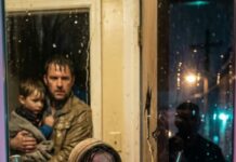 Rain hammered the tin roof when he appeared at my door—soaked, trembling, cradling a boy who looked about eight. “Please,” the stranger rasped, “just five minutes.” I should’ve said no. I had nothing—no money, no locks that worked, no reason to trust anyone. But the child lifted his head and whispered, “Sister… you finally found me.” My stomach dropped. I’d never seen him before. Then the man shoved a damp envelope into my hands. “Whatever you do,” he hissed, “don’t open it until the thunder stops.” And outside—someone started knocking back.