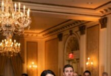 At my husband’s celebration dinner, he clinked his glass and grinned like he was about to deliver the joke of the night. “Meet my wife,” he announced, “no ambition, no plan—just living off my success.” The room exploded in laughter. I didn’t. I smiled, stood up, and raised my own glass. “Enjoy it,” I said calmly. “Because this is the last time you’ll ever make me the punchline.” Then I walked away… and that’s when the real fallout began.