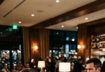 I smiled and refilled his wine like I didn’t understand a word—until he leaned toward his friend and sneered in French, “She’s just a stupid waitress. Probably can’t even read the menu.” My hands froze on the bottle. Across the room, my husband’s eyes narrowed as he lifted his phone. The billionaire kept talking… louder, crueler. And I realized he had no idea who was recording—until it was too late.