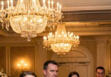 At my sister’s wedding, she mocked me in her speech: ‘My sister is a single mother, unwanted by anyone.’ The room laughed. My mom added: ‘She’s a used product!’. Dad covered his mouth to stifle a chuckle. Then the groom stood up and grabbed the mic. The room froze.