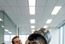 In the middle of the office, he laughed and flipped a bag of trash over my head like it was a joke. “This is where you belong,” he sneered. The room erupted—chairs squeaking, phones buzzing, everyone watching me become a punchline. I didn’t scream. I didn’t run. I picked scraps from my hair, one by one, and met his eyes. “Thanks,” I said softly. “I won’t forget this.” His smile twitched. Nobody noticed… but something inside me had already started moving.