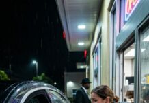 Era Noche de Acción de Gracias cuando entré al drive-thru, buscando algo caliente para no volver a casa llorando. La cajera se inclinó por la ventanilla… y el mundo se quedó mudo. Tenía el lunar de mi hermana, la misma mirada que vi por última vez junto a su ataúd hace veinticuatro años. Me sostuvo la vista y susurró: «Por favor… no grites». ¿Entonces a quién enterramos?