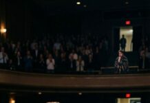 He was in a wheelchair, once bluntly told by his ex-girlfriend, “I don’t want to be a burden.” Years later, he returned as a renowned speaker, telling the story of “the abandoned one.” The audience rose to their feet and applauded, while he looked toward the back row, where a familiar shawl sat. He paused mid-sentence, his voice hoarse: “Is that person here today…?” The shawl shifted—but the face remained obscured.