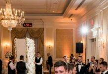 At my son’s wedding, his bride curled her lip and hissed, “Sit by the kitchen doors—your face will ruin the family photos.” My seat went to a stranger. I just smiled, walked to the gift table, and slipped my $25,000 check back into my purse. Leaning close, I whispered, “Don’t worry… I’ll stay out of your life forever.” Three hours later, the band, bar, and flowers disappeared—and so did something much bigger.