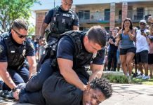 In the crowded apartment complex, Black residents watched as cops used excessive force on a young man, crushing his head into the ground with all their weight. He started foaming at the mouth and nearly passed out cold. The entire block started chanting “Brutality!” and the officers had no choice but to surrender and apologize publicly.